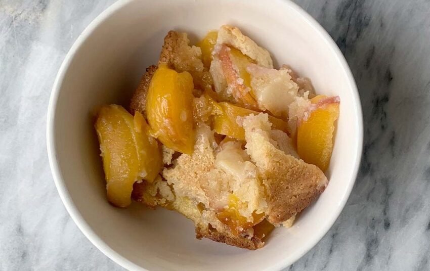 A-bowl-of-lazy-homemade-peach-cobbler-on-marble-cutting-board